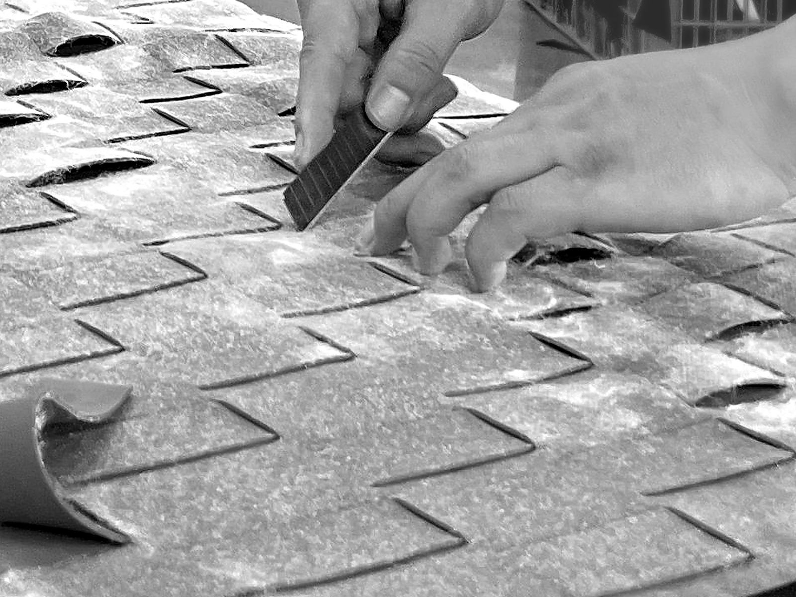 Close detail of hands using a utility knife to cut upholstery fabric
